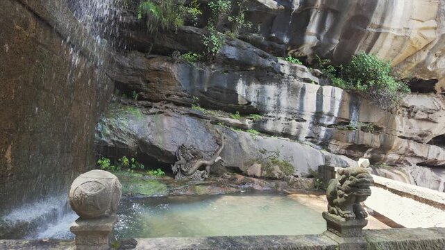 A serene ancient stone temple featuring a natural waterfall flowing into a sacred pool with traditional dragon and lion carvings.