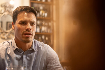 Obraz premium Serious young man talking during dinner date at cozy restaurant
