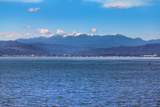 Snow capped southern Tararua ranges, New Zealand, view across Wellington Harbour from Oriental Bay. Petone, Hutt Valley in middle distance. Mt Hector is highest peak. Mt Alpha, Bridge Peak, Field Peak