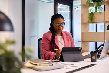 Fototapeta premium African american businesswoman working on laptop in creative office