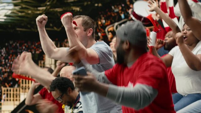 Excited diverse supporters jumping after winning live bet result, stadium crowd with adrenaline enjoying team victory.