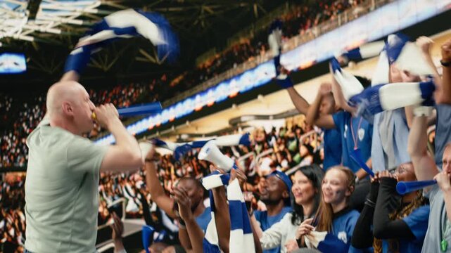 Energetic male football fan blowing blue vuvuzela in stadium terrace while supporters cheer during exciting live soccer match, fan leader and hardcore supporters wearing face paint, stadium noise.