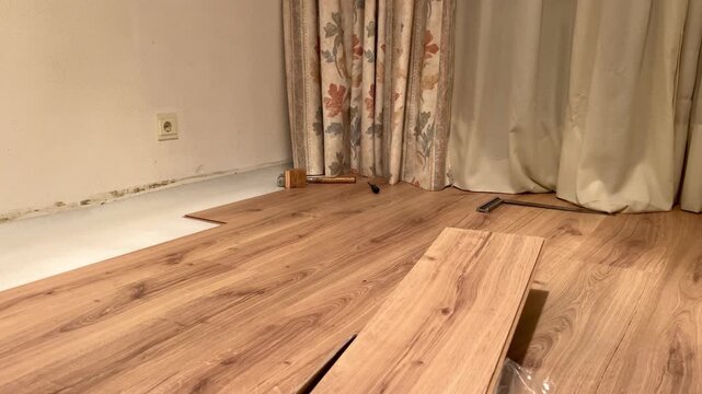 Installing new laminate flooring during home renovation and remodeling process