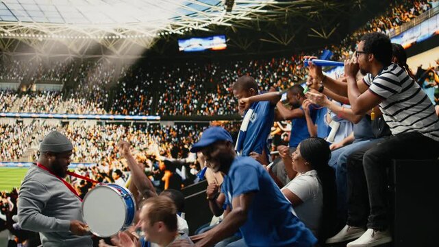 Blue soccer supporters cheering together in crowded stadium during live football match in the supporter section, passionate sports fans celebrate together, crowd cheering and nonstop fan chants.