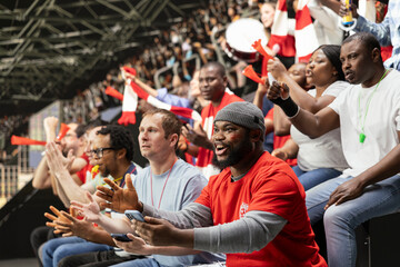 Obraz premium Black football fan excited about big win and team victory at the stadium, successful bet winning ticket on phone. Celebrating a successful cash out and gambling win with crowd excitement.
