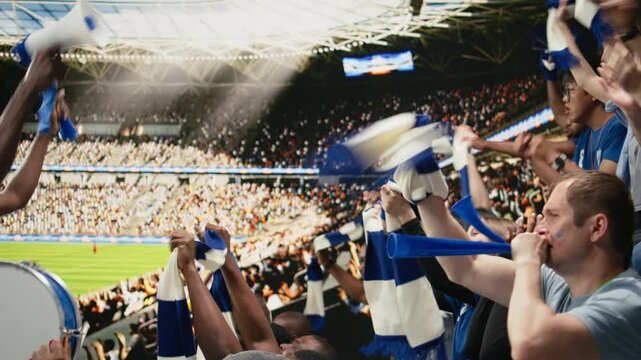 Black football capo leading blue stadium crowd with megaphone and drum, people cheering with vuvuzela and chants during live match, diverse football ultras express team spirit and supporter culture.