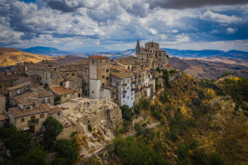 Naklejka premium Aerial drone view of town Petralia Soprana, Sicily, Italy. An avenue of trees leading to the hilltop in the Madonie Mountains. August 2024