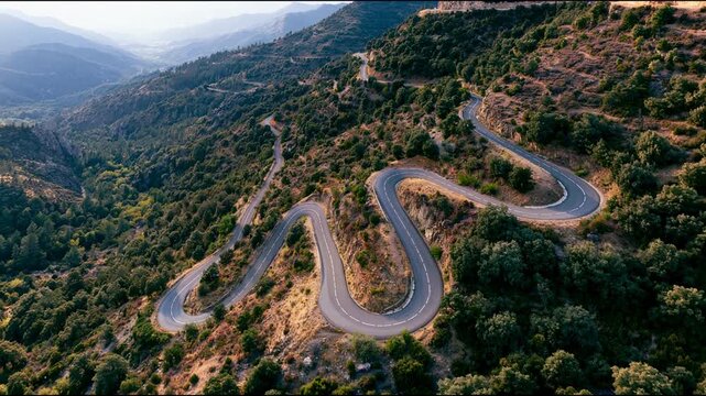 Aerial view of winding mountain road through green valley