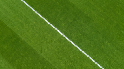 Fototapeta premium Vibrant green field background with a white line, perfect for sports or nature themes