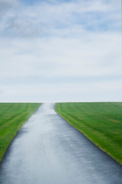 Single lane road crossing green field