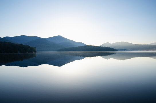Whiteface Mountain reflected on surface of Lake Placid at sunrise