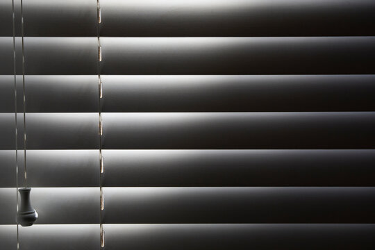 Close-up of window blinds with sunlight