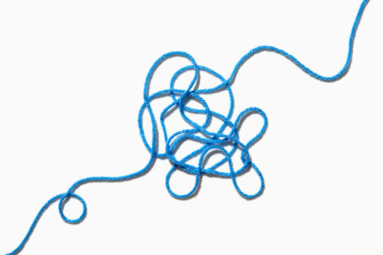 Tangled blue yarn on white background