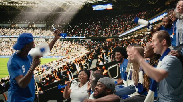 Black football capo within blue supporter crowd and directing stadium chants with megaphone, fan leader during intense live soccer match, diverse soccer ultras express team spirit and celebration.