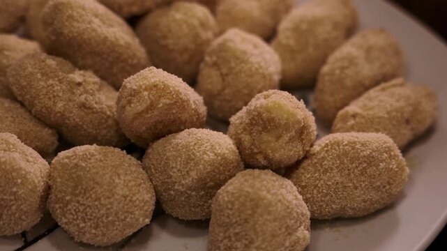 Homemade Breaded Croquettes on White Plate Ready to Fry, Traditional Spanish Recipe. 