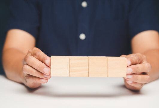 Businesswoman Building Wooden Block Bridge at Desk
