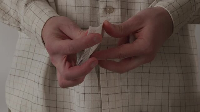 Hands opening a paper drip coffee filter bag closeup