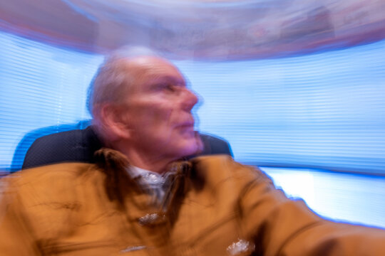 Senior man in desk chair, motion blurred