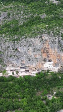 A stunning aerial view of the historic Ostrog Monastery, a Serbian Orthodox church built on a sheer cliff in Montenegro