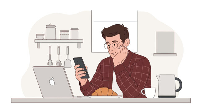 Man using smartphone at kitchen table with laptop and breakfast