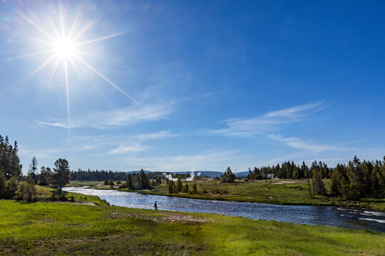 Sun on blue sky over Firehole River