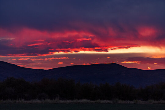 Dramatic clouds over mountains and field