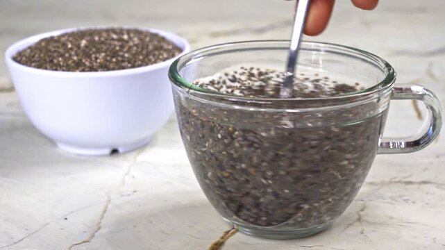 Stirring superfood chia seeds in a glass of water