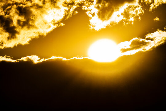 Golden sun setting behind clouds
