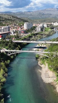 Beautiful aerial view of the city of podgorica, montenegro, with the iconic millennium bridge spanning the emerald waters of the moraca river