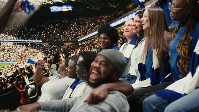 Singing blue team football fans waving scarves and cheering together in packed stadium stands during energetic live soccer match, team spirit and celebration inside the packed stadium.