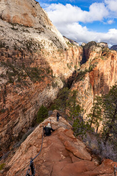 Hikers descending Angels Landing Trail holding chains