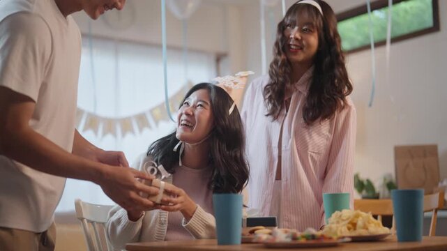 A group of teenage friends celebrated a birthday party, singing songs and happily exchanging and opening gifts.