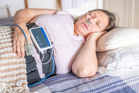 Woman resting in bed with home medical monitoring device, nasal cannula oxygen, Diagnostic procedure detecting apnea monitoring, pulse oximeter, quiet recovery, healthcare at home, calm resilience