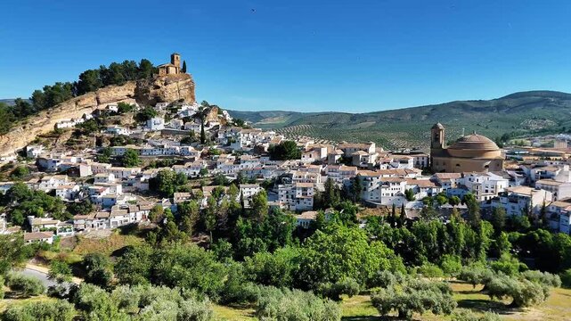 wide landscape view of Montefrio white village with castle on a cliff and church dome, Granada province in Spain