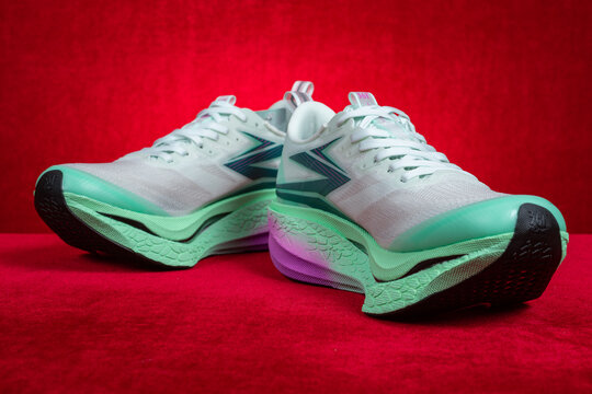 Zhongshan China-March 7 2026: 361 white and green running shoes for boy on red.