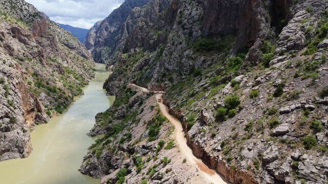 Aerial of Karasu River with the legendary hand-carved Stone Road visible on the cliff with rock carved tunnel in Canyon in Kemaliye, Turkey. adventure travel destination