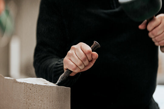 stone mason is working with different tools like chisel, mallet or hammer