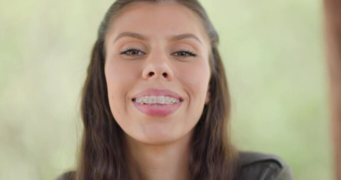 Close encounter with a young woman displaying curiosity and intensity in a natural setting during daytime