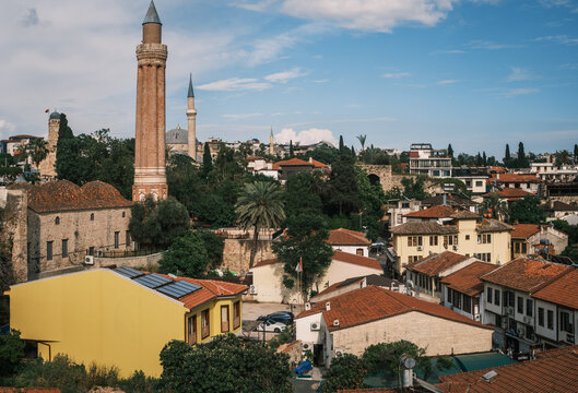 Scenic view of Yivli Minare Mosque fluted minaret rising above traditional red tiled roofs in Antalya old town Kaleici, historic seljuk landmark and urban cityscape, Turkey.