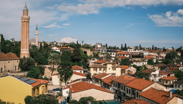 Scenic view of Yivli Minare Mosque fluted minaret rising above traditional red tiled roofs in Antalya old town Kaleici, historic seljuk landmark and urban cityscape, Turkey.