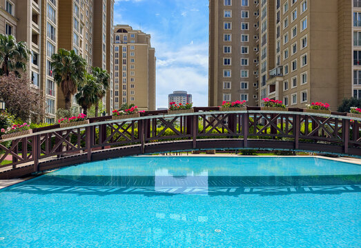 City landscape with a pool and bridge surrounded by buildings and plants