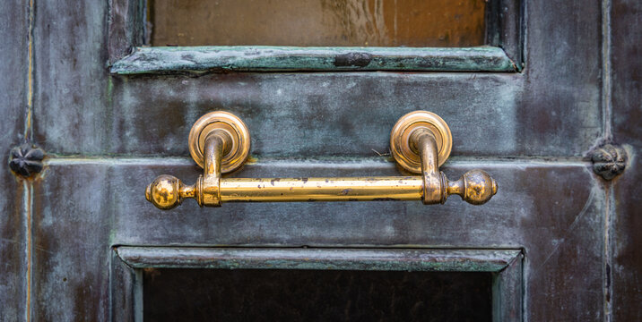 Goldener T&uuml;rgriff an einer Bronzet&uuml;r mit Patina