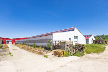 Naklejka premium Industrial warehouse exterior with stacked wooden pallets