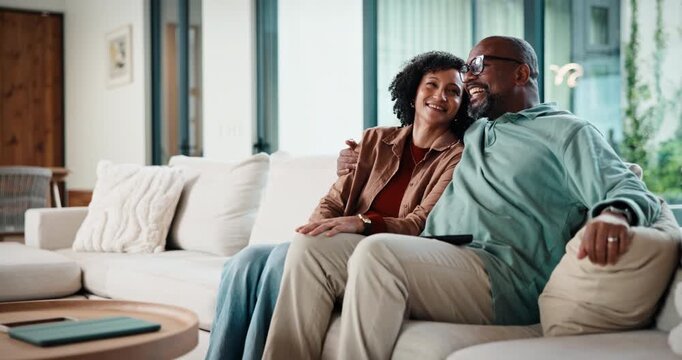 Couple, watching tv and hug on couch with smile, choice or love with streaming in living room. Mature African man, woman and embrace with movie, television and subscription on sofa in lounge at house