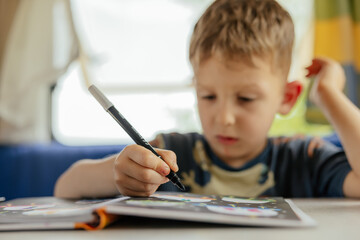 Preschooler doing exercises in a camper van in summer.  © belyaaa