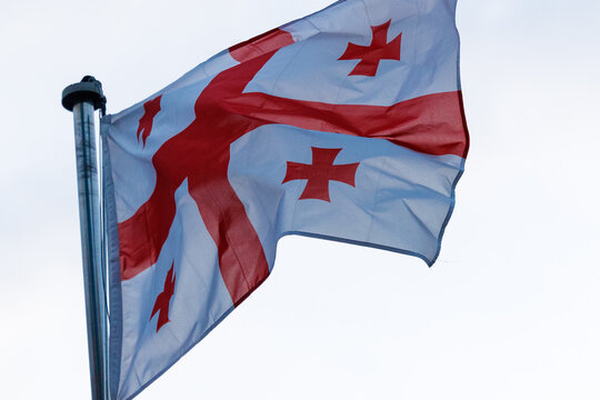 Georgian National Flag Waving Against Bright Sky