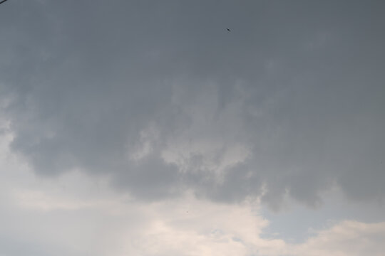 Stormy sky ahead. Chaotic cloud formations suggest imminent turbulence and turbulent winds. Rough layers of gray clouds and uneven shadows point to unstable weather situation