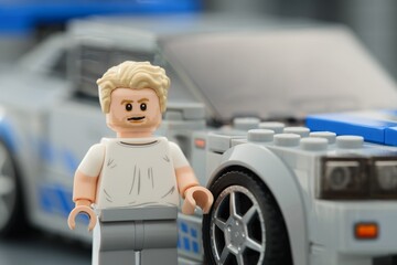 Obraz premium Tambov, Russian Federation - August 21, 2025 Portrait of Lego Brian OConner minifigure near his Nissan Skyline GT-R (R34) car. Close-up. Lego Speed Champions