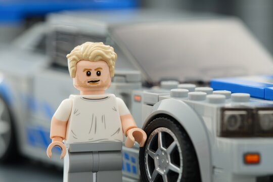 Tambov, Russian Federation - August 21, 2025 Portrait of Lego Brian OConner minifigure near his Nissan Skyline GT-R (R34) car. Close-up. Lego Speed Champions