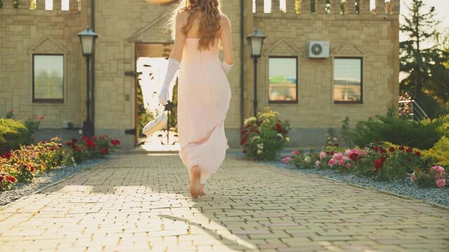 Art portrait fairy girl princess close-up hands holding handbag reticule small bag with beads walks on old style city street sun light. vintage lady woman long white gloves peach dress back, rear view